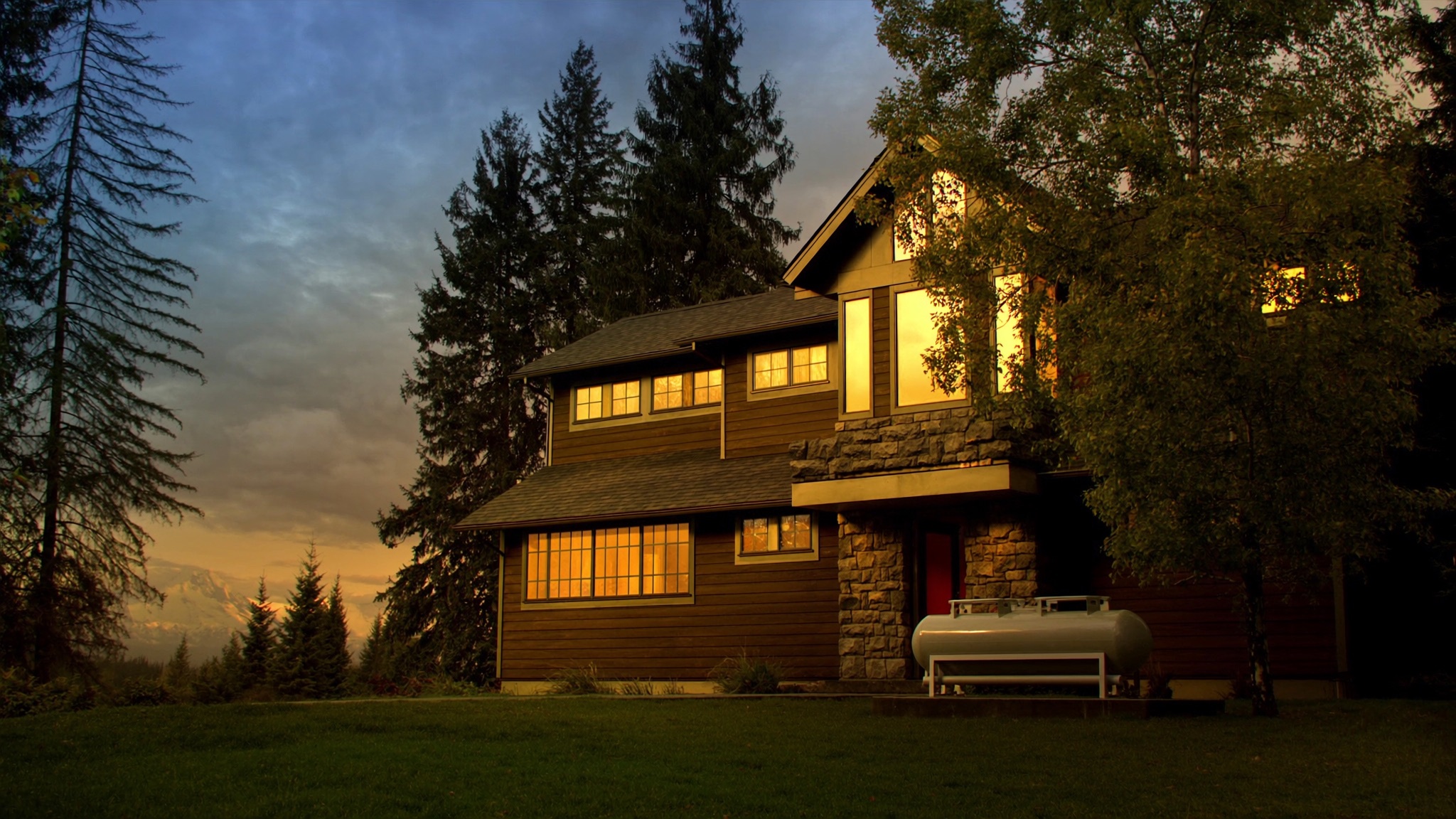 A Pacific Northwest home at dusk with a residential propane tank in the yard
